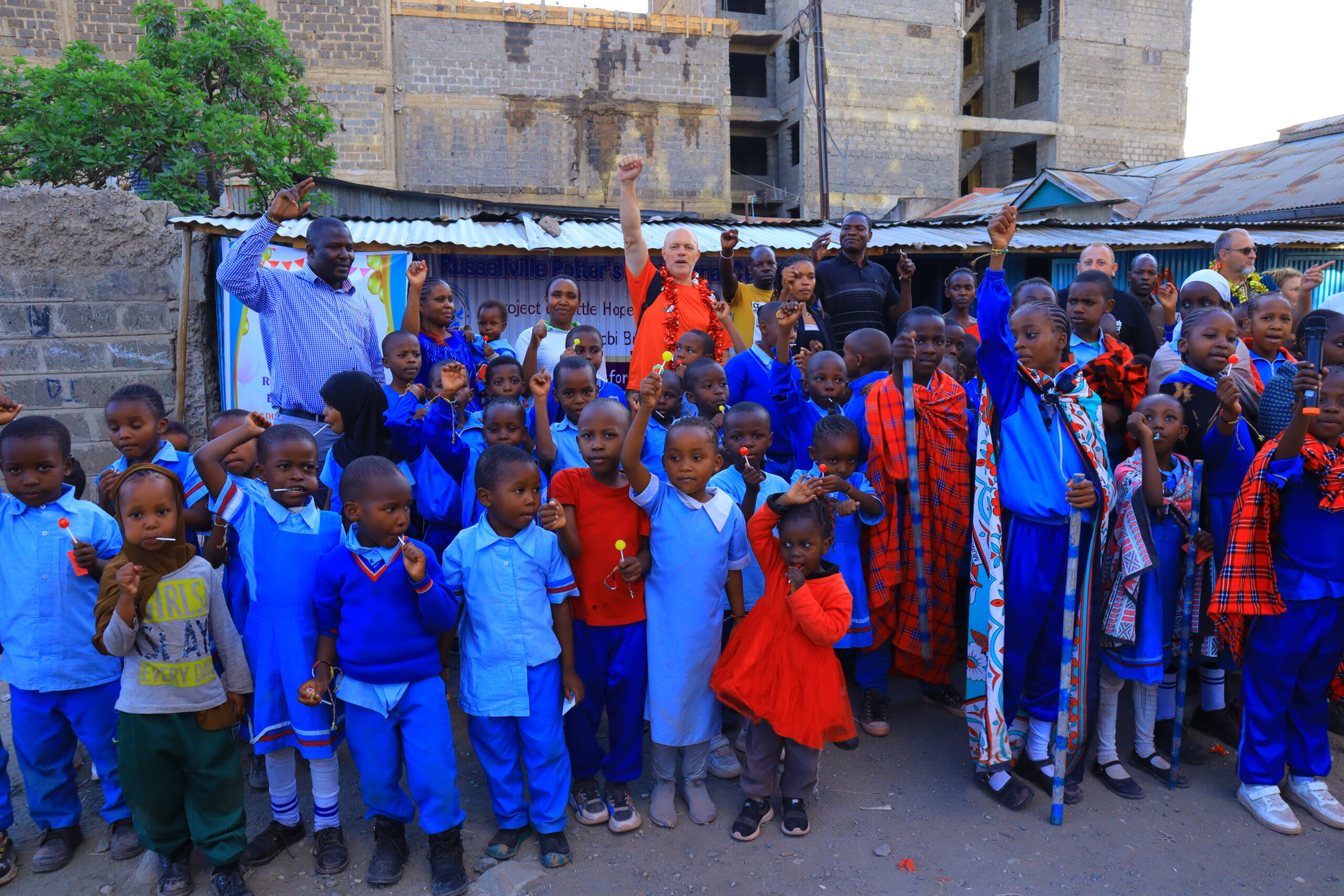 Children and ministry participants gathered outdoors during a Kenya community visit